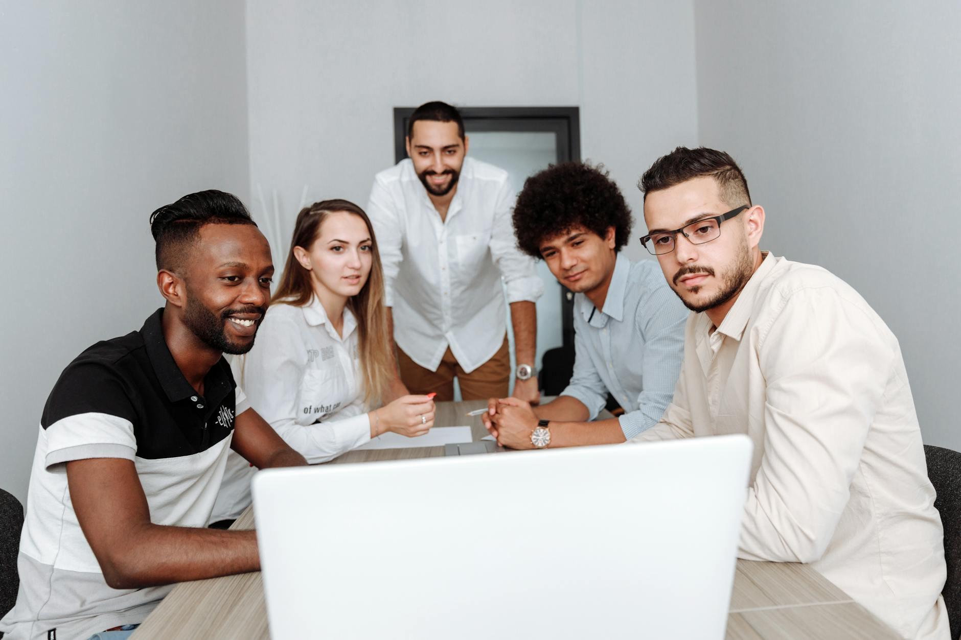 Colleagues reviewing client work together on a laptop